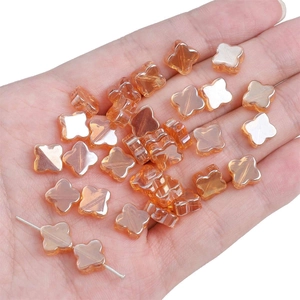 Dettaglio di perle a quadrifoglio in vetro ambrato con effetto specchio per gioielli DIY
