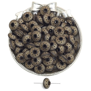 Detail of vintage gold acrylic spacer beads for DIY jewelry making in a silver tray