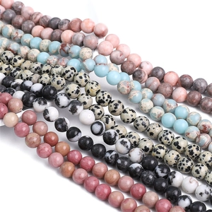Macro shot of 6mm-8mm natural stone beads including dalmatian jasper and rhodonite for DIY