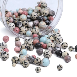 Mix of natural stone round beads for DIY jewelry making falling from a glass jar