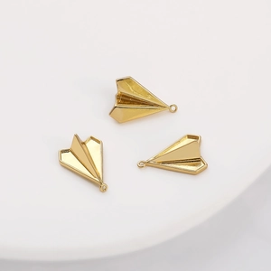 Detailed macro shot of three 14K gold plated paper plane pendants for DIY jewelry making