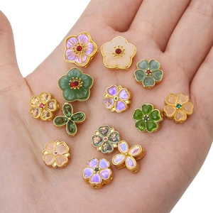 Exquisite gold-plated sakura flower spacer beads for DIY jewelry making in palm view