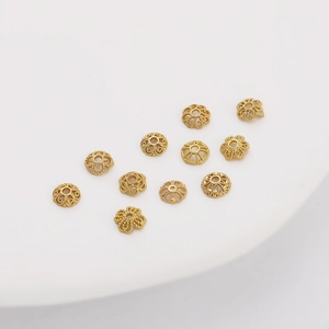 Vue macro des perles d'espacement fleurs filigranées plaquées or 18K pour bijoux DIY
