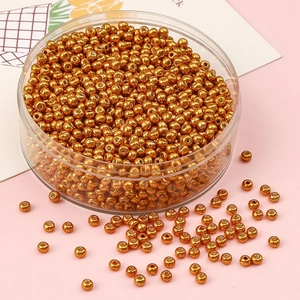 Gros plan de perles de rocaille dorées métalliques pour bijoux DIY en récipient clair