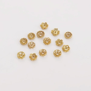 Détail de calottes de fleurs évidées dorées et d'entretoises pour la création de bijoux DIY
