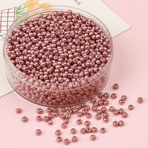 Vue détaillée de perles de rocaille roses métallisées pour la création de bijoux DIY
