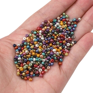 Mélange de perles de verre métalliques 2mm pour bijoux DIY dans une paume