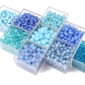 Mix of blue glass crackle and jelly beads for jewelry making in a plastic organizer box