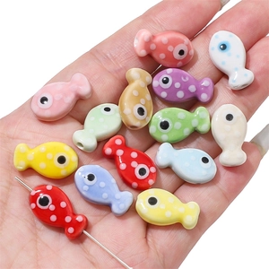 Colorful polka dot fish ceramic beads for handmade jewelry held in hand