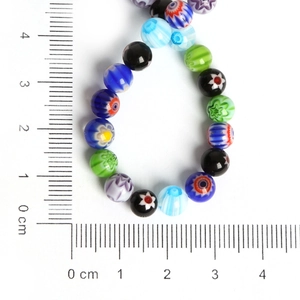 Detailed view of colorful Millefiori glass beads with size scale for DIY jewelry making
