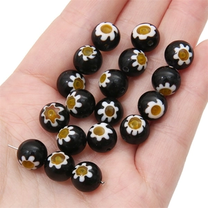 Macro view of millefiori glass beads with black base and white floral patterns