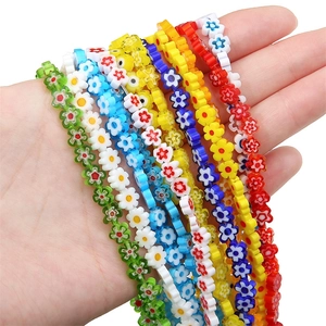 Macro shot of colorful plum blossom glass beads held in hand for DIY jewelry making