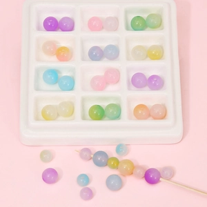 Macro detail of colorful matte acrylic jelly beads in a white tray for DIY jewelry making