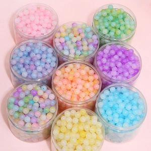 Assorted colorful matte acrylic round beads in clear jars for DIY jewelry making