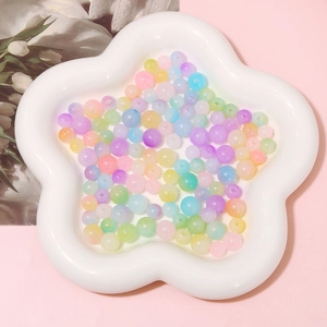 Close-up of colorful acrylic jelly round beads for DIY jewelry making in a white bowl