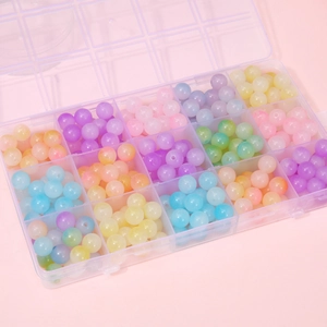 Macro shot of colorful matte acrylic jelly beads organized in a plastic 15-grid storage box