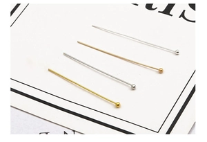 Detailed view of copper ball head pins in gold and silver for DIY jewelry making