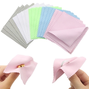 Detail view of colorful microfiber jewelry cleaning cloths polishing rings on white background