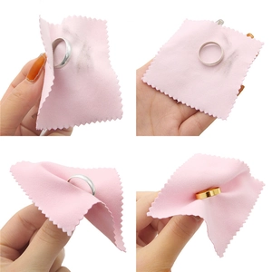 Detail of pink microfiber cleaning cloths wiping gold and silver rings for maintenance