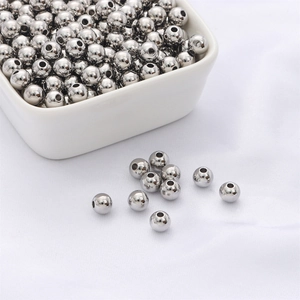 Cuentas espaciadoras redondas de plata pulida para joyas en un cuenco blanco