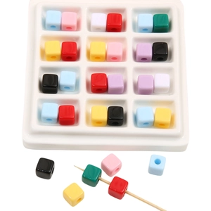 Close-up of colorful acrylic cube spacer beads with holes for DIY jewelry making