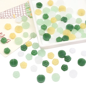 Detailed macro view of assorted jade-like beads in floral, round, and Fu blessing shapes