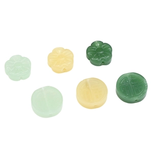 Detailed view of DIY jade-like glass beads in pumpkin and fortune patterns for jewelry