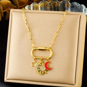 Détail du collier chaîne trombone doré avec pendentifs étoile, lune et lune en émail rouge