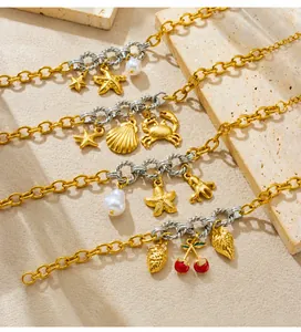 Detailaufnahme von nautischen Gold- und Silberarmbändern mit Seestern- und Muschelmotiven