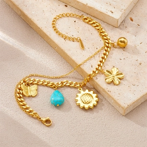 Detail of a double-layer gold plated bracelet with butterfly and sun flower charms