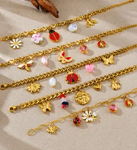 Detailed close-up of gold-plated bracelets featuring colorful insect and floral charms