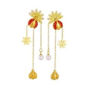 Détail de boucles d'oreilles à pompons dorés avec coccinelles marguerites perles et émail