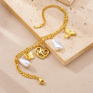 Detail of gold stainless steel bracelet with Mom heart charm and baroque pearl charm