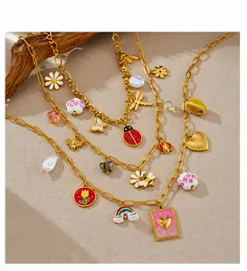 Detailed close-up of gold plated necklaces with daisy bee tulip and ladybug enamel charms