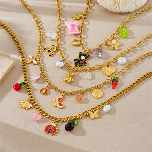 Detailed view of chunky gold necklaces with colorful charms like bears, bees and butterflies