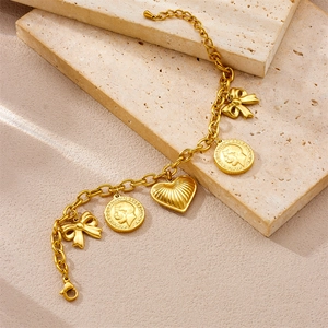 Gold chain bracelet featuring vintage coin charms, bowknots, and heart pendant on stones