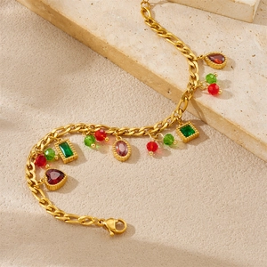 Detailopname van gouden Figaro-kettingarmband met kleurrijke edelsteenhangers