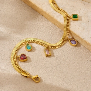 Detail van een vergulde dubbellaagse armband met vijf kleurrijke edelsteen hangers