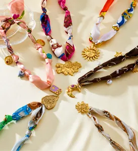 Details von Seidenbandketten mit goldenen Vintage-Anhängern wie Sonne und Mond
