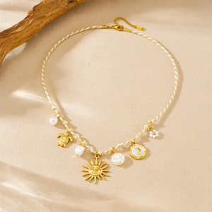 Bohemian braided necklace with gold-plated sun, moon, sea turtle and baroque pearl charms
