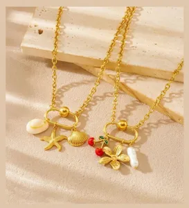 Gold-tone necklace set featuring starfish, shell, cherry, and pearl charms, elegant and chic detail.