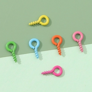 Assorted colorful iron eye pins for DIY jewelry making displayed on a green background