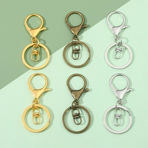 Flat lay of metal lobster clasp keychain sets in gold, bronze, and silver finishes