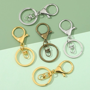 Flat lay of lobster claw clasp keychain sets in gold, silver, and bronze finishes