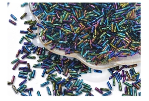 Macro view of 2x6mm twisted bugle beads in iridescent metallic colors on glass dish