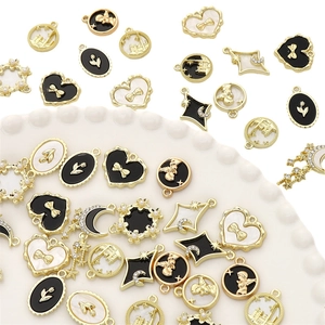Detail of assorted gold plated alloy pendants with black and white enamel for DIY jewelry