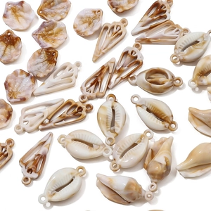 Detailed view of acrylic sea shell charms with amber marble texture for DIY jewelry making