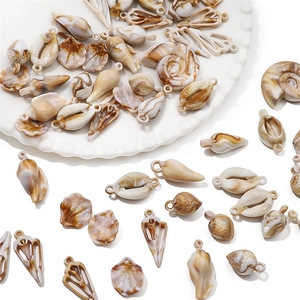 Macro detail of acrylic sea shell charms with brown marble texture for DIY jewelry making