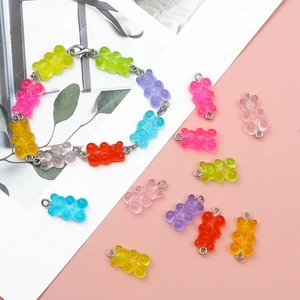 Colorful translucent resin gummy bear charms and bracelets on an aesthetic background