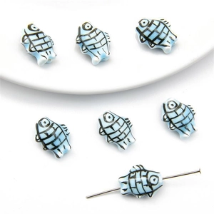 Macro detail of hand-painted blue ceramic fish bead with grid texture for DIY jewelry